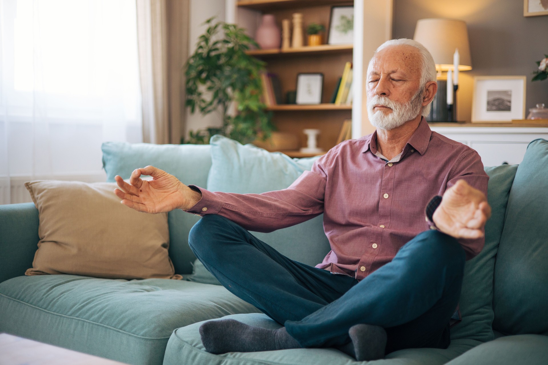 senior man meditates at home.